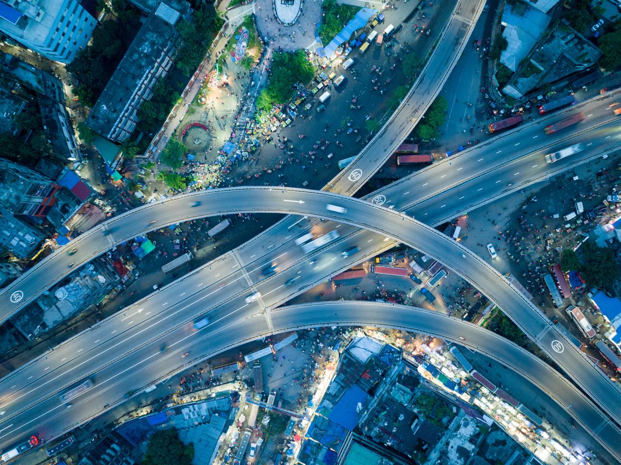 Dynamic aerial shot of a bustling city highway intersection at night.