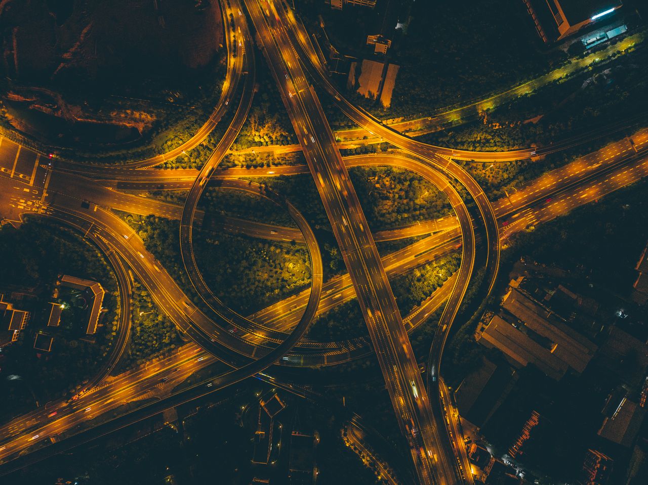 A striking aerial view of Xiamen highway interchange illuminated at night, highlighting intricate road patterns.